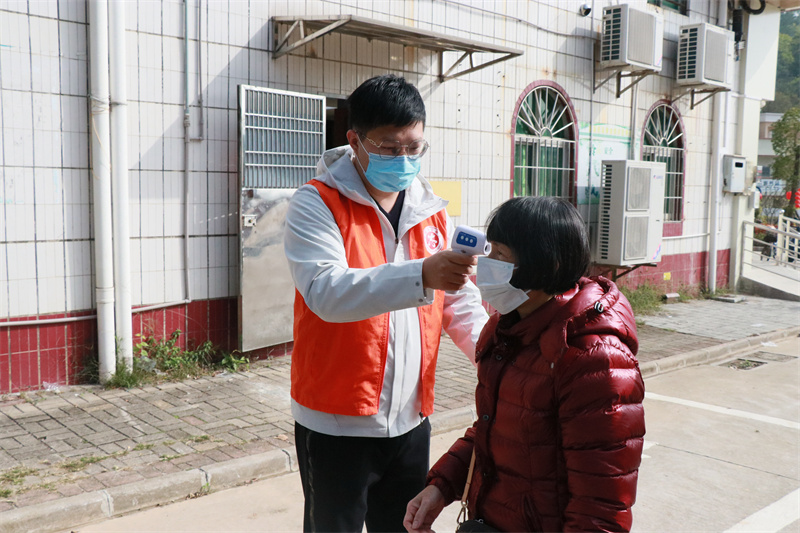 江门挂职驻村第一书记黄锐科现场对群众进行测温.JPG